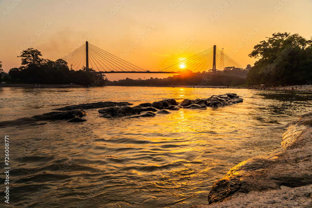 Golden sunset near a river and a bridge