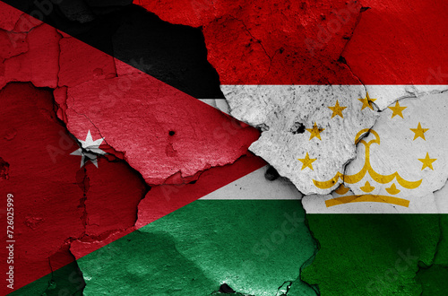 flags of Jordan and Tajikistan painted on cracked wall