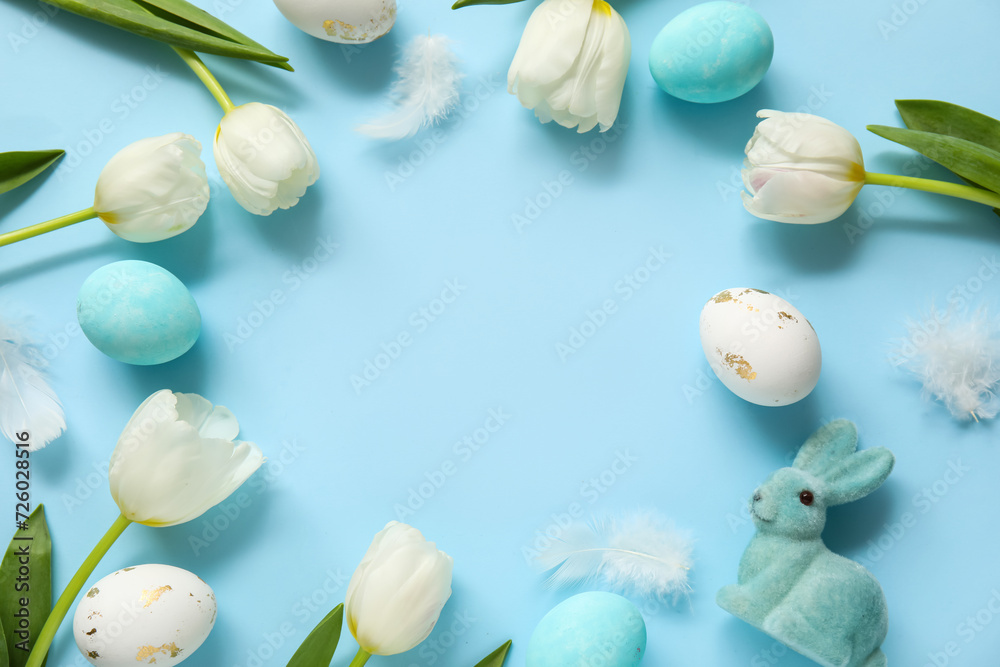 Frame made of tulips, Easter bunny and eggs on blue background