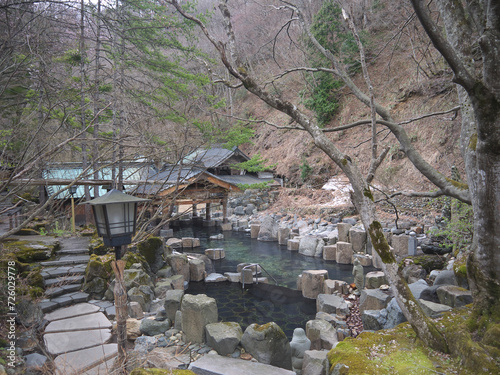 Traditional Japanese onsen hot spring Rotenburo open air bath on mountain river in the forest, Takaragawa, Japan