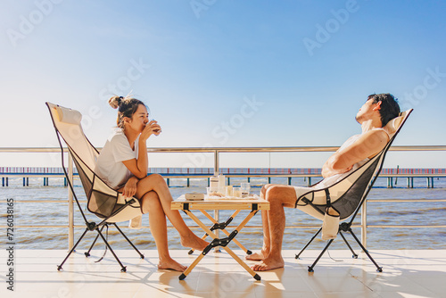 Asian couple lover enjoy their holiday at the sea in the summer with beautiful clear sky ocean view. © Sevendeman