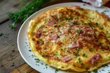 Cheesy ham pancake displayed on white plate resting on wooden table