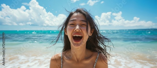 At a tropical beach, an Asian woman shouts at the ocean, with a web page design concept.