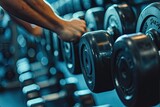 Strong man grabs heavy dumbbell at gym