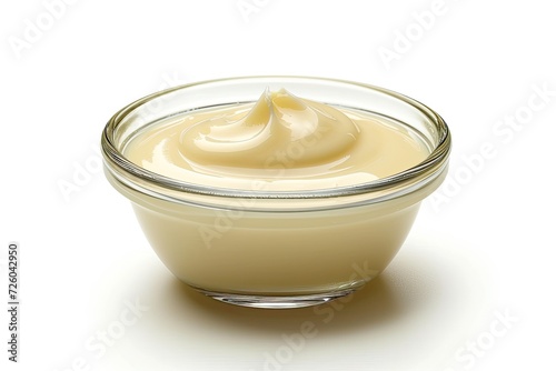 Condensed milk in glass bowl on white background photo