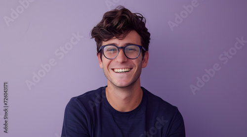 a smiling man wearing glasses in front of a purple background