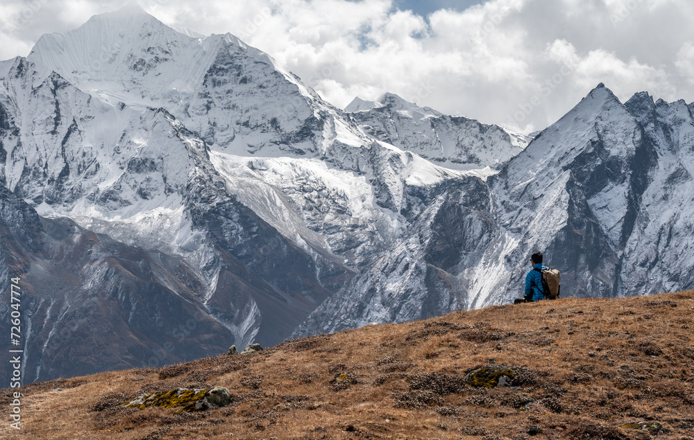 Rear view of tourist sitting on top of Tsergo Ri (4,990m) the high point on the Langtang valley trek of Nepal.