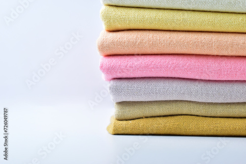 stack of colourful cotton clothes, pile of clothing on white background