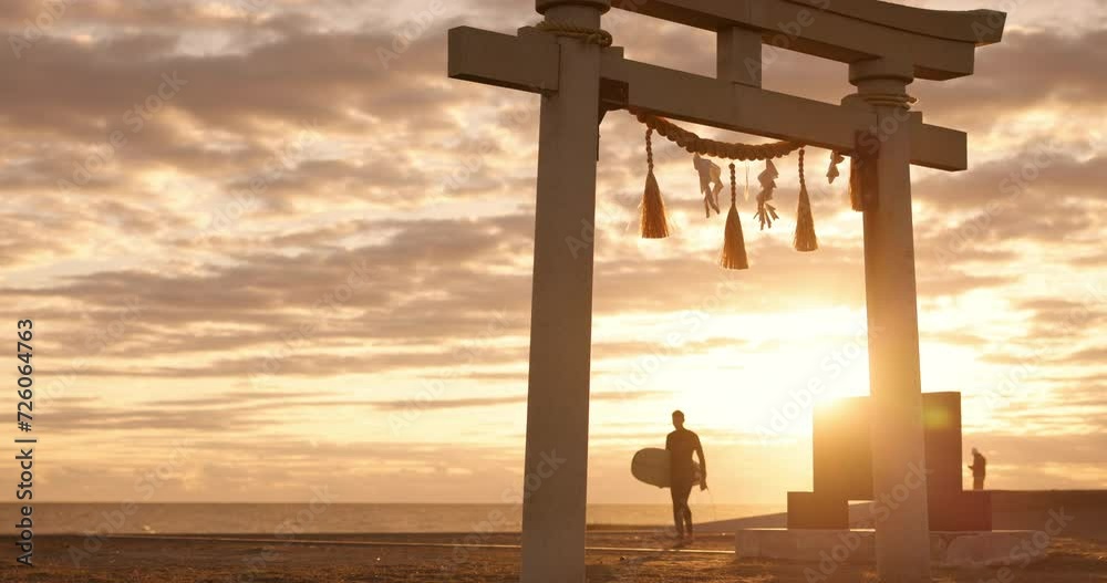 Torii gate, sunset sky and man at ocean with surfboard, spiritual