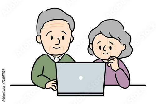 パソコンを笑顔で操作するシニアの夫婦