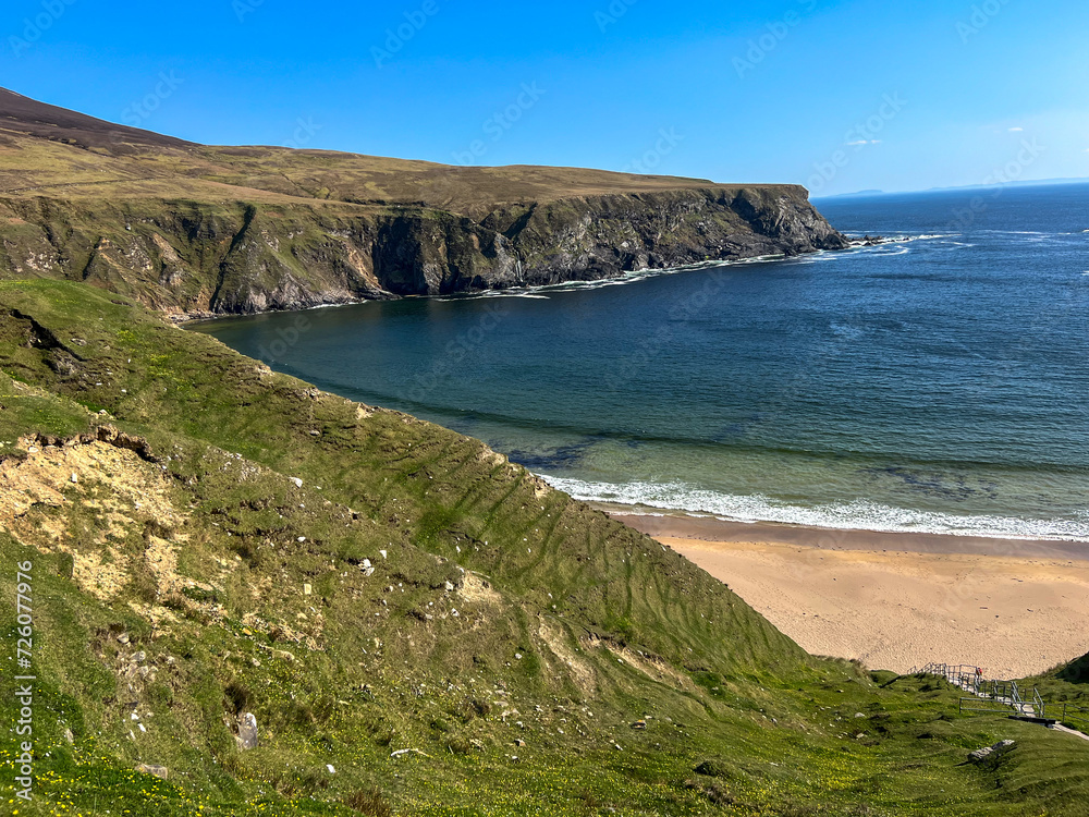 Blue sky, cliffs and sandy beach at Silver Strand Beach, Malin Beg, Ireland