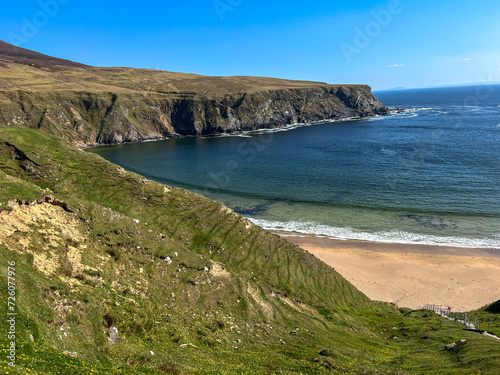 Blue sky, cliffs and sandy beach at Silver Strand Beach, Malin Beg, Ireland