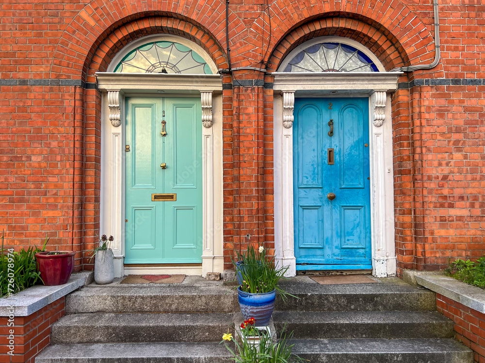 Colorful green and blue doors in red brick wall with stairs, Dalkey, Ireland 