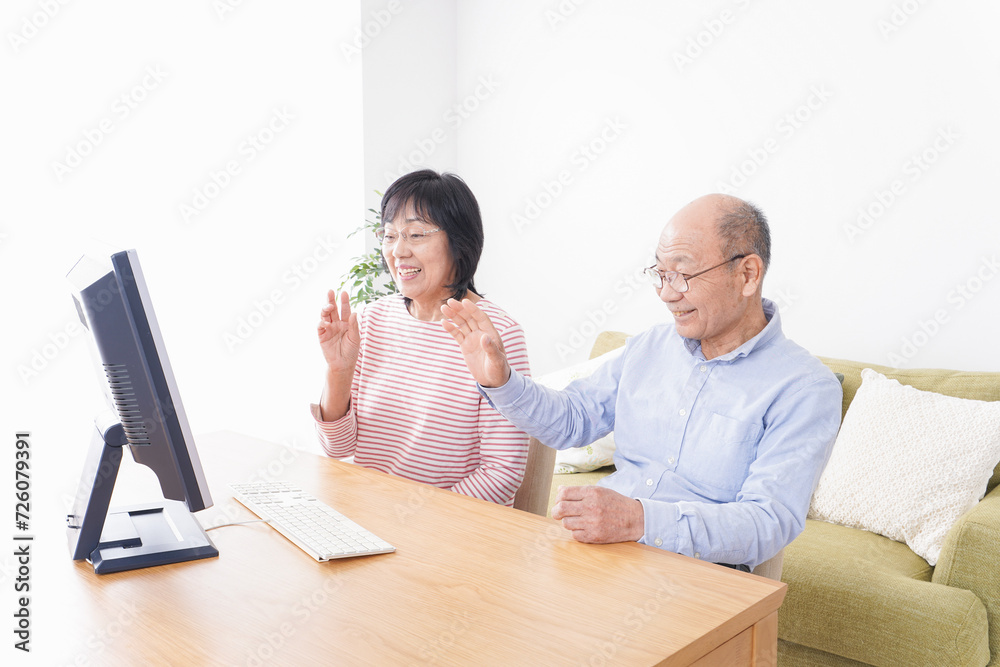 パソコンでテレビ電話をする高齢の夫婦 パソコンでテレビ電話をする高齢の夫婦