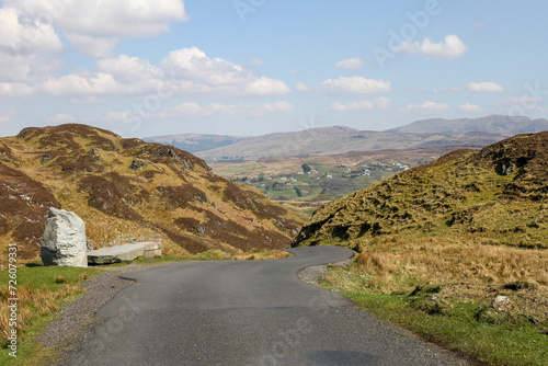 Winding road leading away to blue sky and mountains and cliffs at Slieve League, County Donegal, Ireland