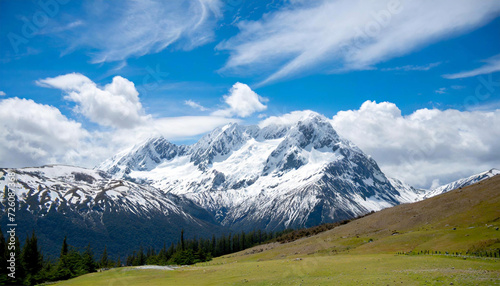 snowy mountain, the sky is clear with a bright blue sky and puffy white clouds; suitable for background or wallpaper