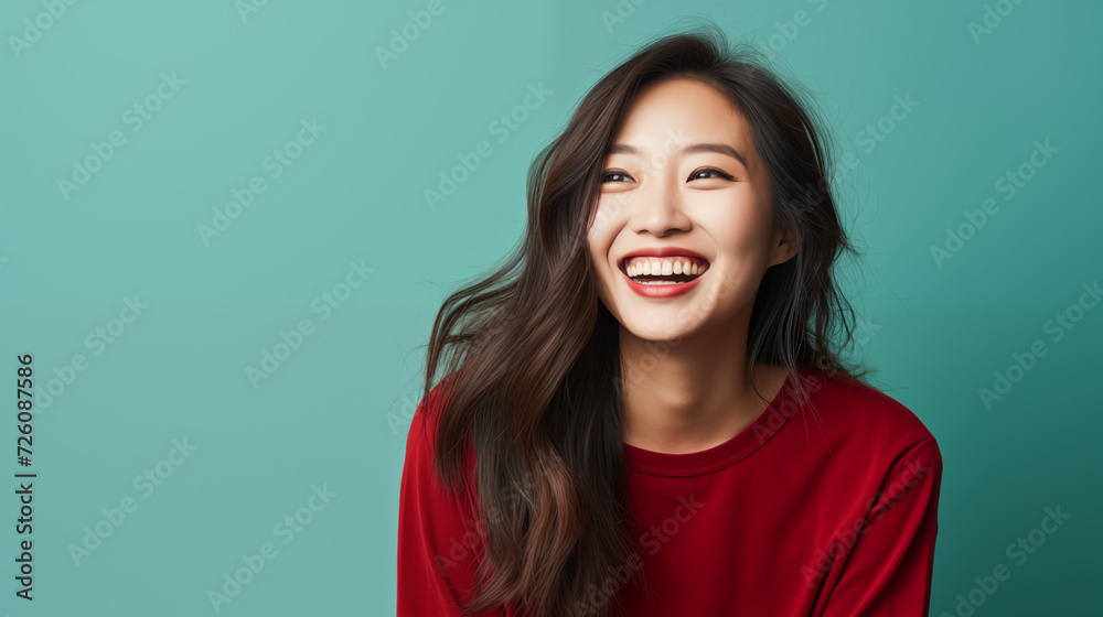 Fototapeta premium Happy dynamic asian woman smiling on a plain background