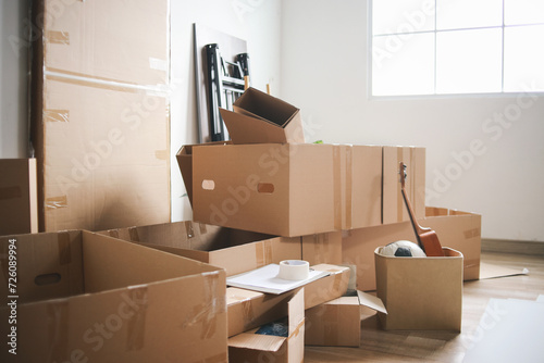 Open cardboard logistic boxes with housing stuff. Messy containers placed on floor of new home, flat, apartment after delivery © Gatot