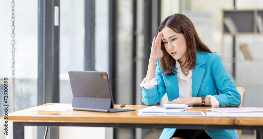 Shot of stressed, sleepy and bored business asian woman sitting at a desk on laptop for a long time and looking worried, tired and overwhelmed Shot of stressed, sleepy and bored business asian woman sitting at a desk on laptop for a long time and looking worried, tired and overwhelmed