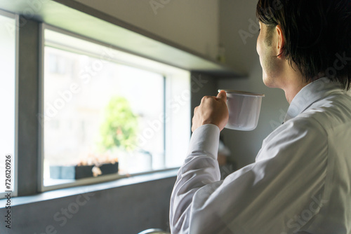 朝マグカップでコーヒー・白湯・お湯・水・お茶・紅茶を飲むビジネスマン 