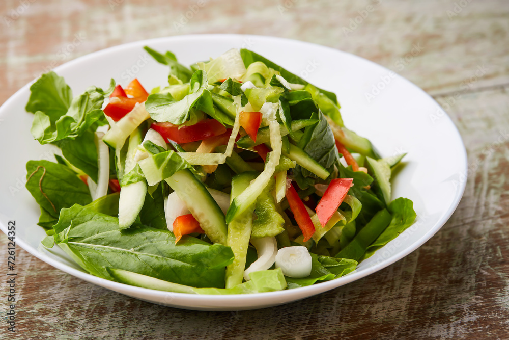 Arugula Salad with tomato, onion, cucumber served in dish isolated on table top view of arabic food