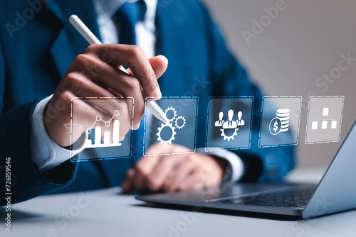 Business analytics concept, Businessman use laptop with virtual business strategy icon to analyze profit and finance performance.