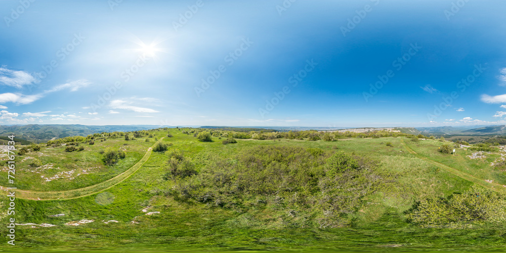Wide panoramic view on mountain landscape with lush green hills under clear blue sky, tranquil natural beauty, perfect for outdoor enthusiasts. Seamless 360 degree spherical equirectangular panorama.
