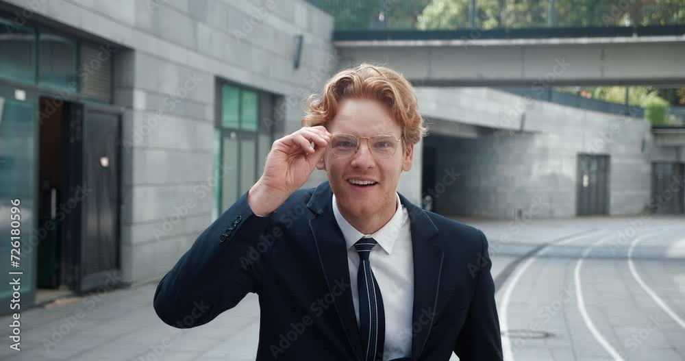 Handsome man in classic suit lowers glasses in surprise and smiles joyfully. Ginger man joy unexpectedly meeting acquaintance on street. Concept human joy and positive emotions from unexpected meeting Handsome man in classic suit lowers glasses in surprise and smiles joyfully. Ginger man joy unexpectedly meeting acquaintance on street. Concept human joy and positive emotions from unexpected meeting
