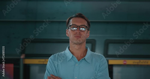 Man stands on platform with his back to train. Train passes by handsome man looking thoughtfully at camera. Slow motion, train rushes by at high speed, creating contrast with motionless figure person.
