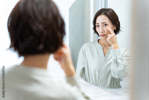 鏡を見て首を気にする日本人女性 photo