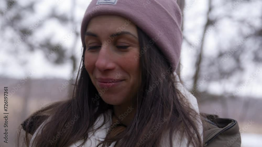 Attractive woman in 20s in winter outdoors looks towards camera Attractive woman in 20s in winter outdoors looks towards camera