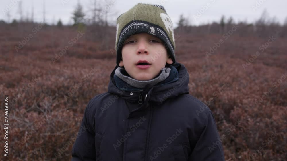 Young boy outdoors on nature walk in late autumn takes deep breath Young boy outdoors on nature walk in late autumn takes deep breath