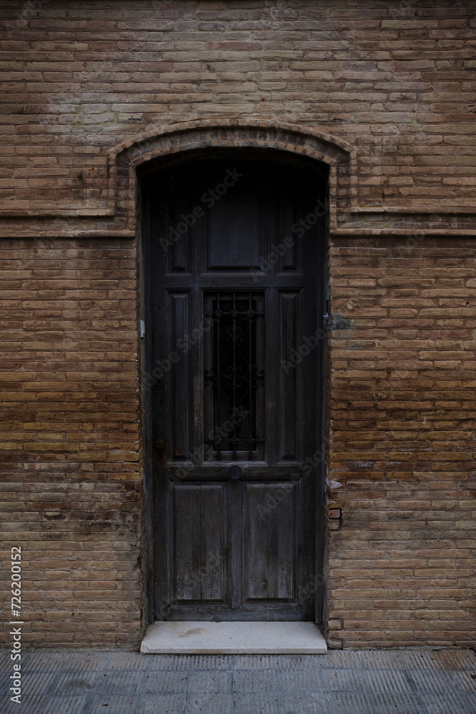 Puerta antigua de madera en una fachada de ladrillo