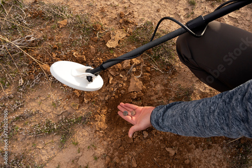 Waterproof Metal Gold Detector and Male's Palm Holding Old Coins. Excavation, Search for Treasure Or Ancient Relics. Archeology, Minesweeper. Horizontal Plane. Detectorists.