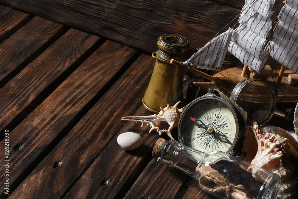 Sea travel or piracy concept background. Sea ship boat, compass and compass on the wooden desk table background.