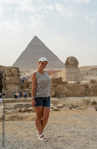Italian tourist girl stands against the backdrop of the Sphinx