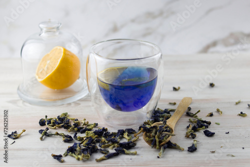Glass cup of organic blue Anchan tea on a light foul. Herbal tea. Clitoria ternatea