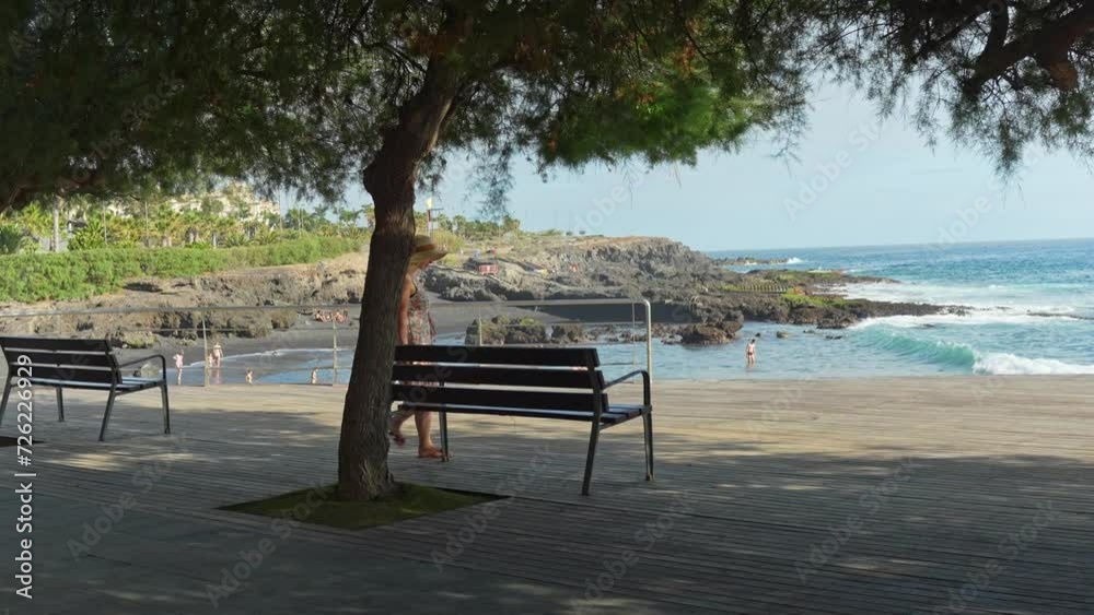 Young attractive woman walk and sits under the tree near Atlantic ocean Young attractive woman walk and sits under the tree near Atlantic ocean