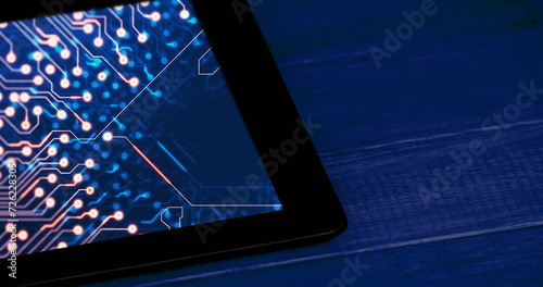Image of tablet with data processing on blue background