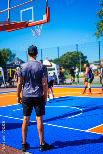 Basketball referee at a game in an outside court during summer holidays.