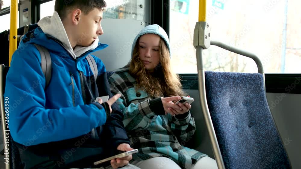 two teenagers in blue clothes sit on bus Canada Vancouver hoods autumn winter spring tracksuits use a mobile phone search for geolocation travel travelers real life two teenagers in blue clothes sit on bus Canada Vancouver hoods autumn winter spring tracksuits use a mobile phone search for geolocation travel travelers real life