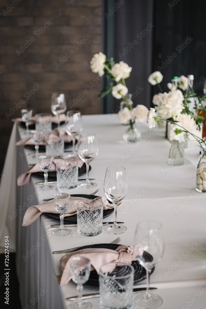 Fototapeta premium Plate and glass, stack, wineglass, luxury rich decor. Wedding set up, dinner table reception on terrace. Serving, setting table in the backyard. Birthday, baptism, event. Closeup details of interior.