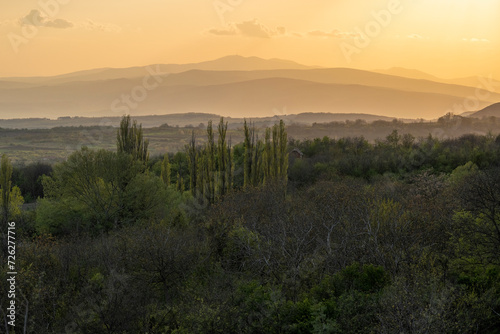 Sunset over mountains, forests, meadows and farmland. Beautiful sunset in the mountains. Sunset View from the Top of a Mountain.