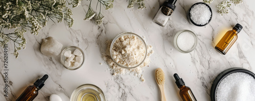 An overhead shot of an elegant bathroom countertop adorned with glass jars of sea salt, pumice stones, and various essential oils, showcasing a luxuri photo