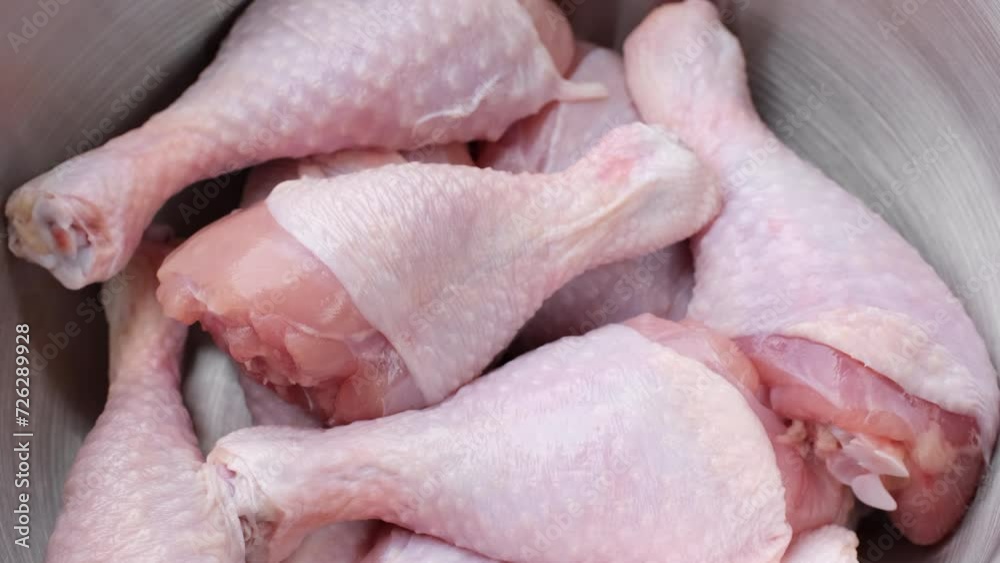 Fresh raw chicken legs in plate, rotation