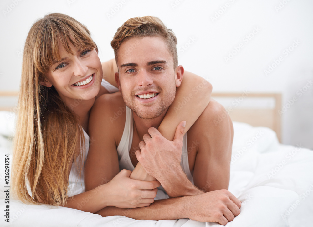 Couple, embrace and portrait in bed on weekend, happy and bonding for love in relationship at home. People, loyalty and commitment to marriage in bedroom, smiling and romance or comfortable in hug