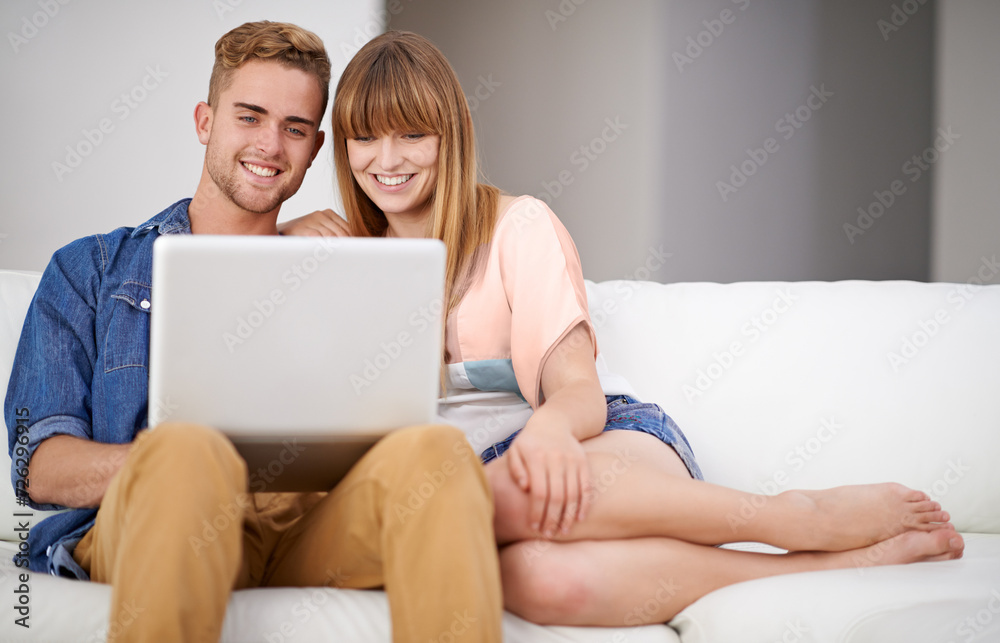 Happy, couple and relax with laptop on sofa, watch movies and subscription for streaming in home. Online, man and woman together on couch reading with computer on website, blog or media on internet