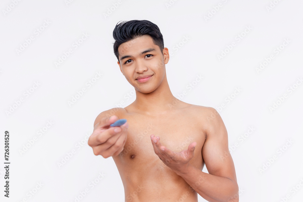 A young undressed asian man showing a leftover used bar of deodorant soap. Isolated on a white backdrop. A young undressed asian man showing a leftover used bar of deodorant soap. Isolated on a white backdrop.