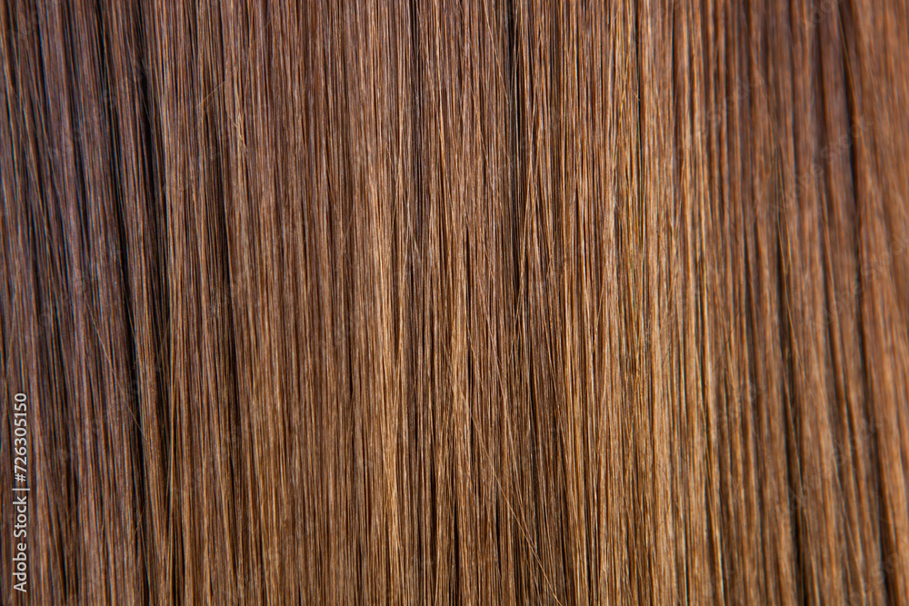 Naklejka premium Close up of brown hair as background. Texture of natural hair..