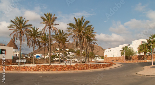 Plaza de Joan Hugo en el pueblo Las Negras de Almería, España. Plaza rodeada de asfalto para la circulación de vehículos y decorada con palmeras. © AngelLuis